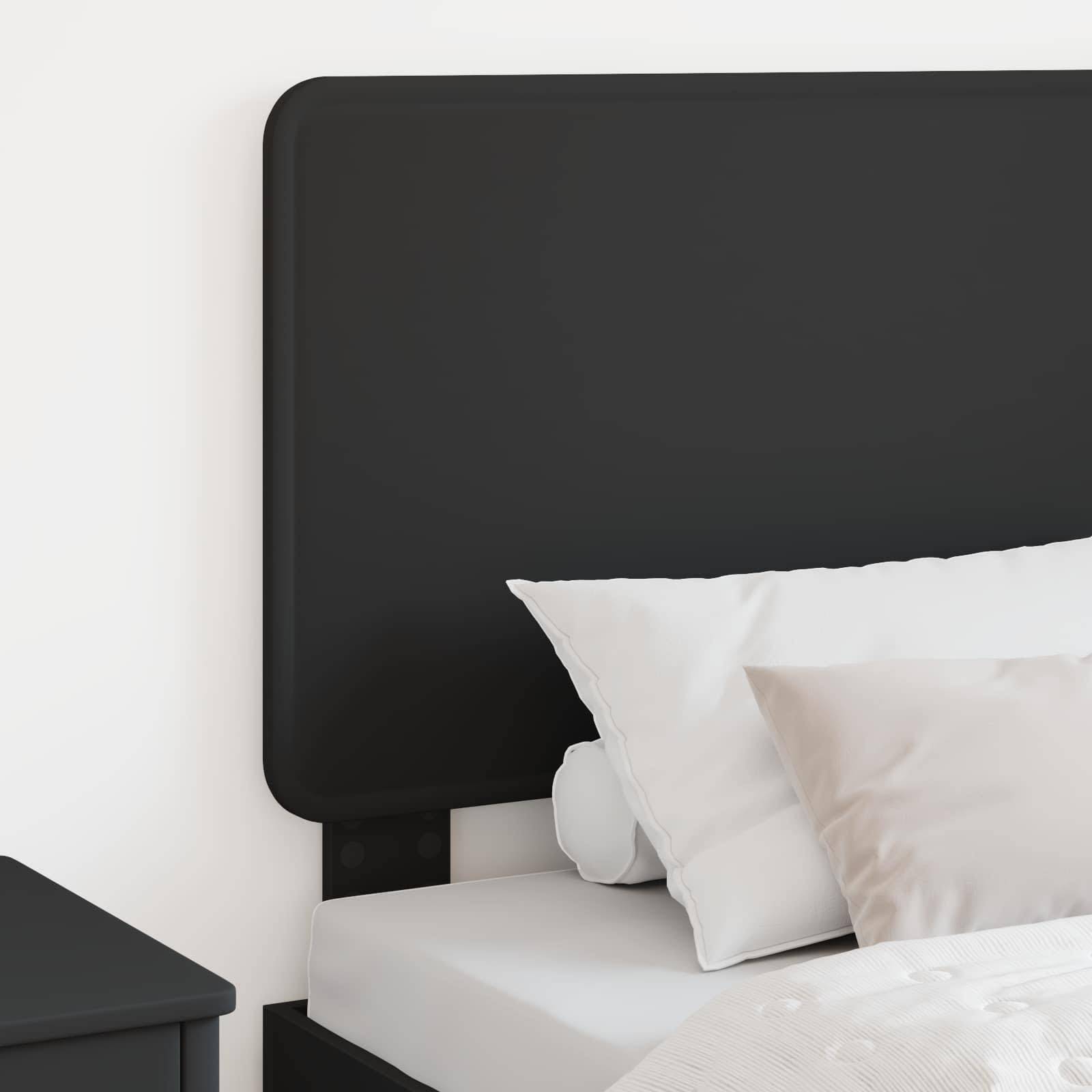 Ein ordentlich gemachtes Bett mit schwarzem Kopfteil und weißer Bettwäsche, ausgestattet mit zwei Kissen, neben einem Nachttisch.