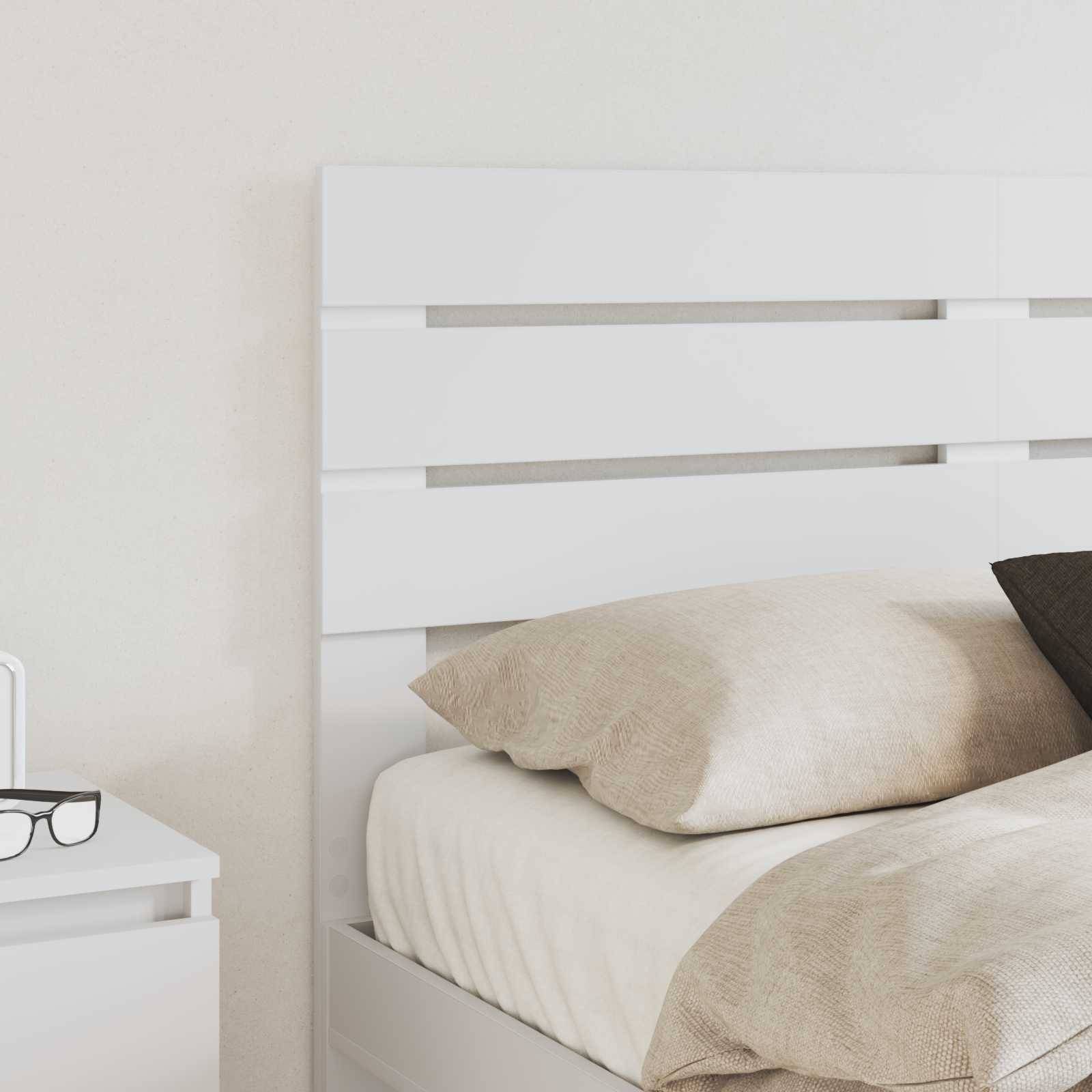 Ein ordentlich gemachtes Bett mit hellfarbigen Kissen und einer Decke, neben einem Nachttisch mit einer Brille, das eine ruhige Schlafzimmeratmosphäre vermittelt.