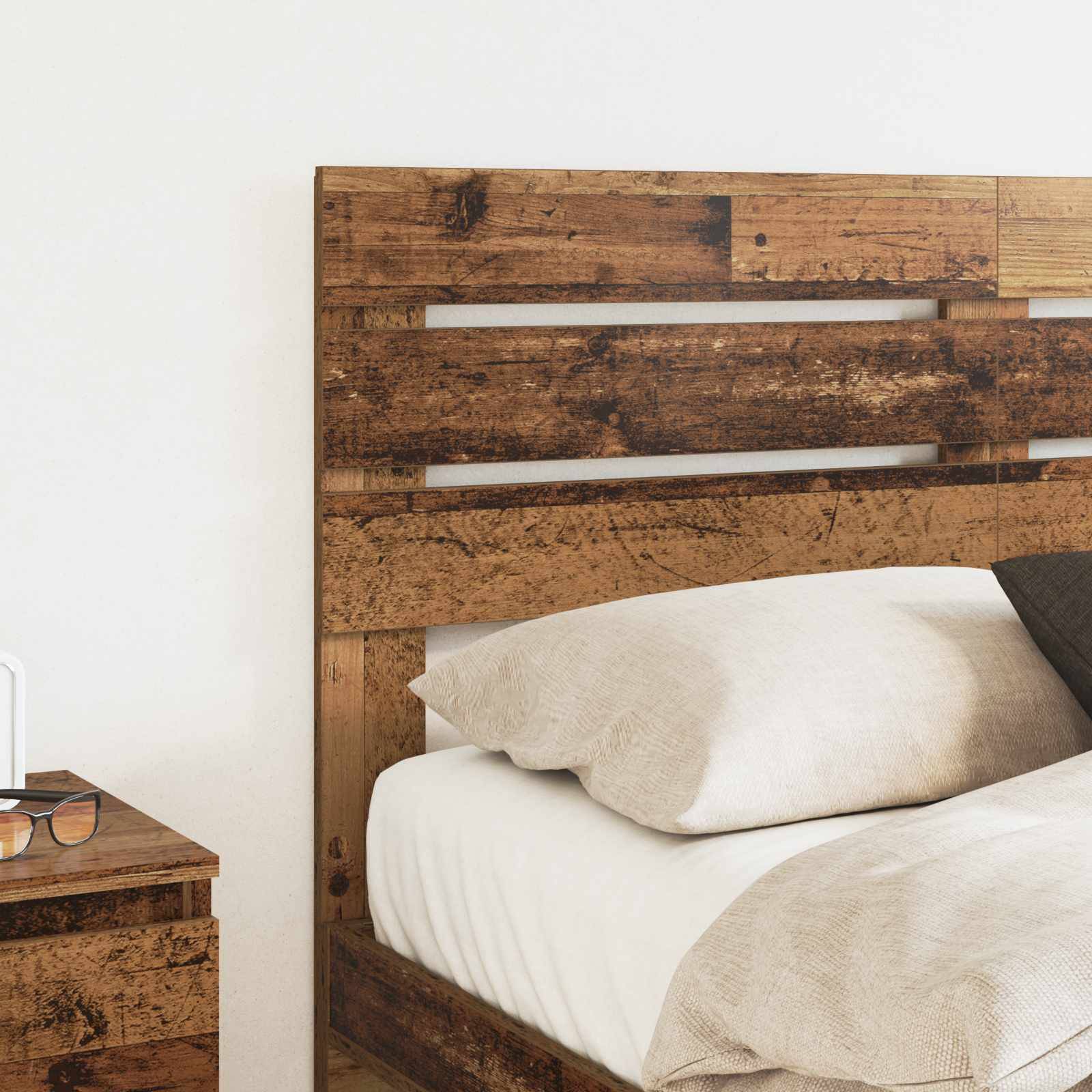 Kopfbrett aus Holz und Nachttisch mit weißem Bett und beigefarbener Bettwäsche, die eine rustikale und gemütliche Schlafzimmeratmosphäre schaffen.