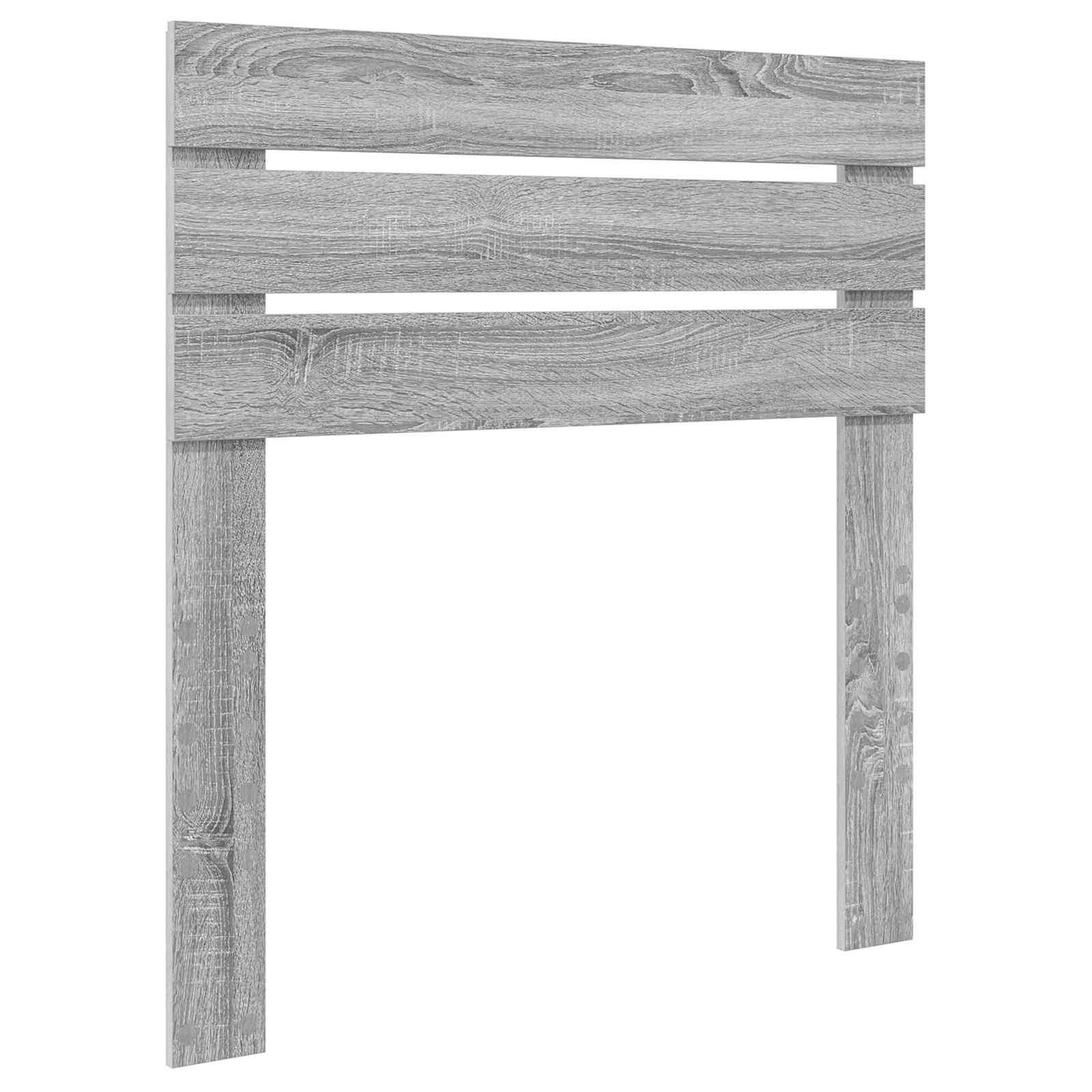 Ein ordentlich gemachtes Bett mit beigen Kissen und einer passenden Steppdecke vor einem hellgrauen Kopfteil mit Betonoptik. Ein Nachttisch ist teilweise sichtbar.