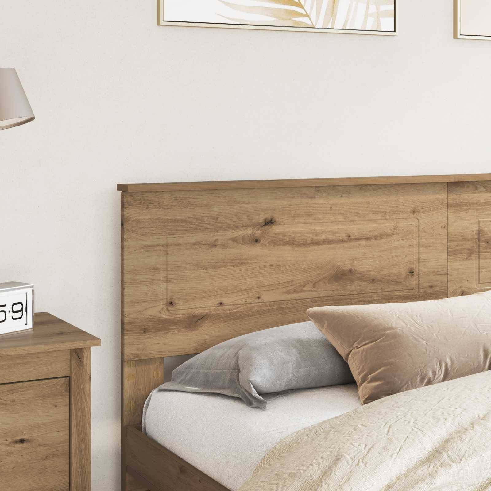 Ein gemütliches Schlafzimmer mit einem hölzernen Kopfteil, cremefarbenem und grauem Bettzeug und einem Nachttisch mit einer Lampe, das eine warme und einladende Atmosphäre schafft.