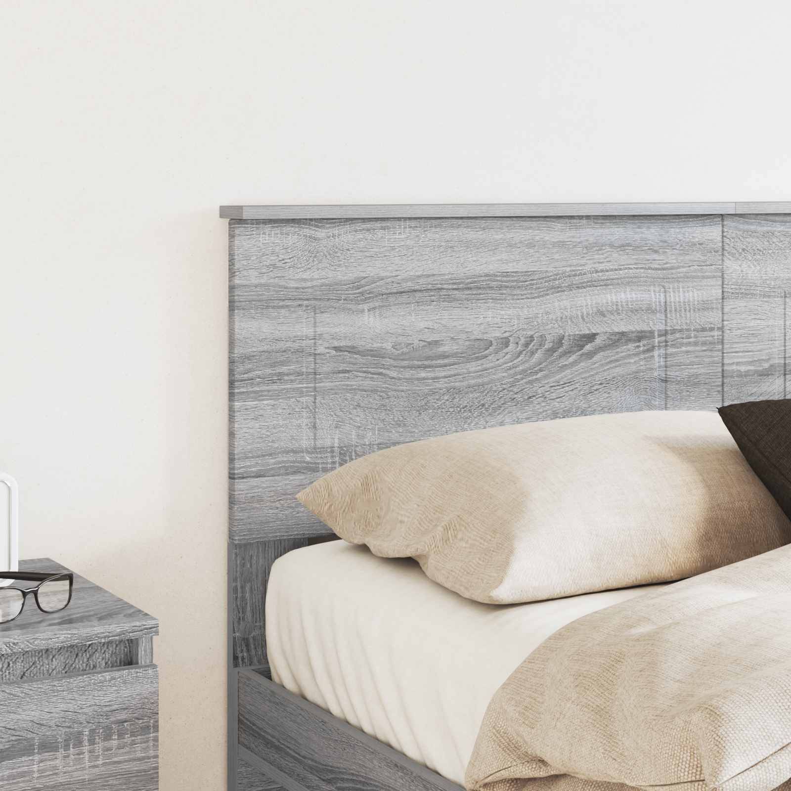 Ein sorgfältig gemachtes Bett mit hölzernem Kopfteil und neutralfarbiger Bettwäsche in einer minimalistischen Schlafzimmereinrichtung.