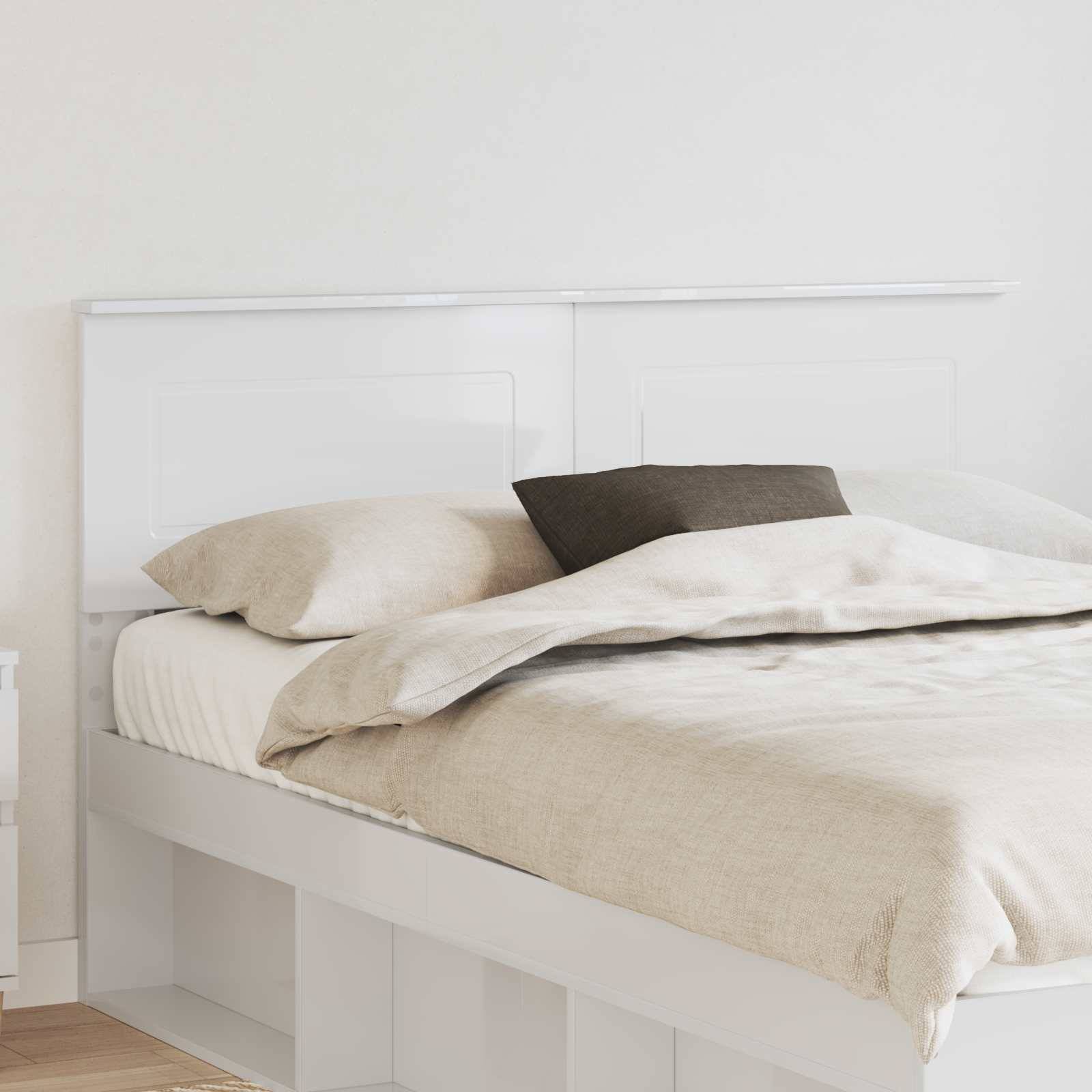 Ein sorgfältig gemachtes Bett mit beigefarbener Bettwäsche, weißen Kissen und einem dunklen Akzentkissen in einer hellen, minimalistischen Schlafzimmerumgebung.