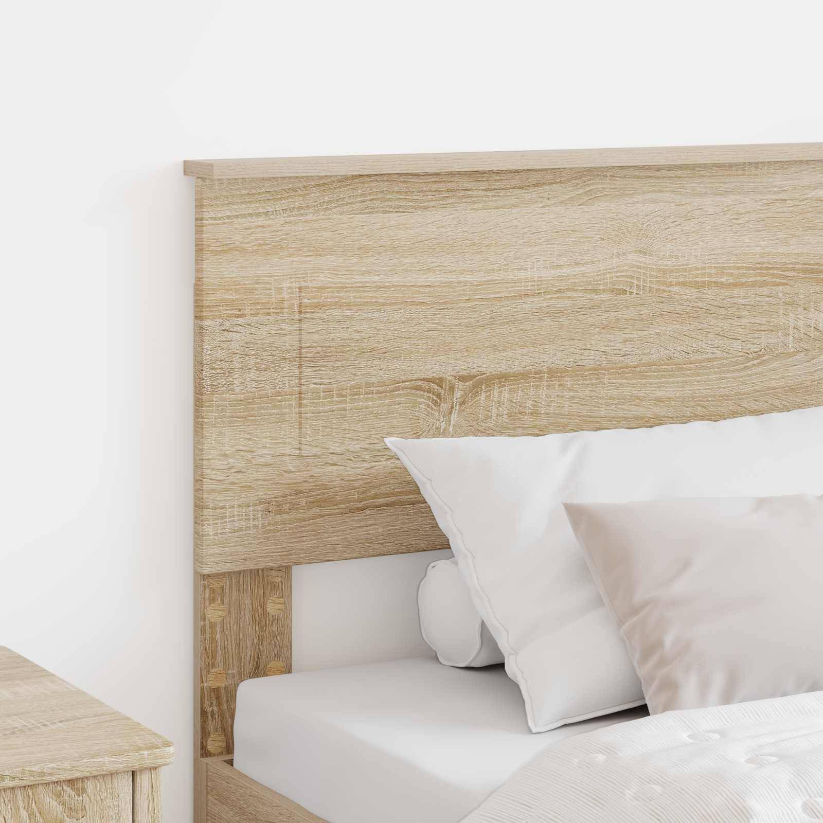 Holzbett mit weißer Matratze und Kissen an einer einfachen Wand; Teil einer minimalistischen Schlafzimmerausstattung mit einem Holznachttisch.