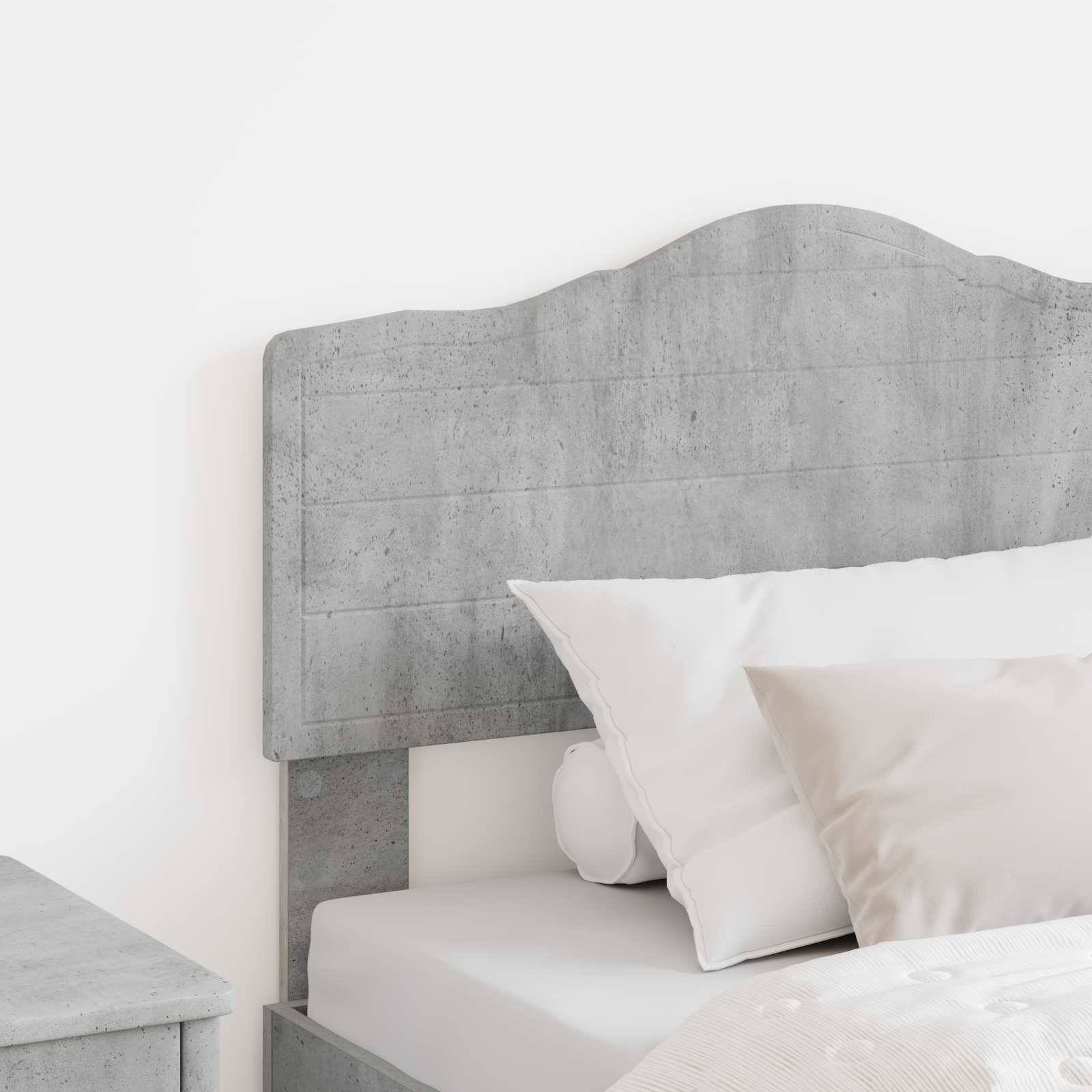 Ein minimalistisches Schlafzimmerambiente mit einem Kopfteil aus Betontextur, weißer Bettwäsche und Kissen, die eine moderne Ästhetik schaffen.