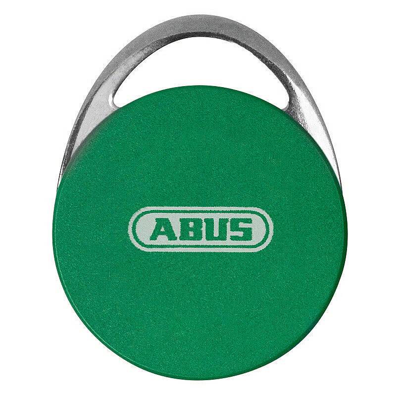 Ein rundes, grünes Schlüsselanhänger mit der Aufschrift 'ABUS' in der Mitte, versehen mit einer metallischen Schlaufe oben zum Befestigen an einem Schlüsselring.