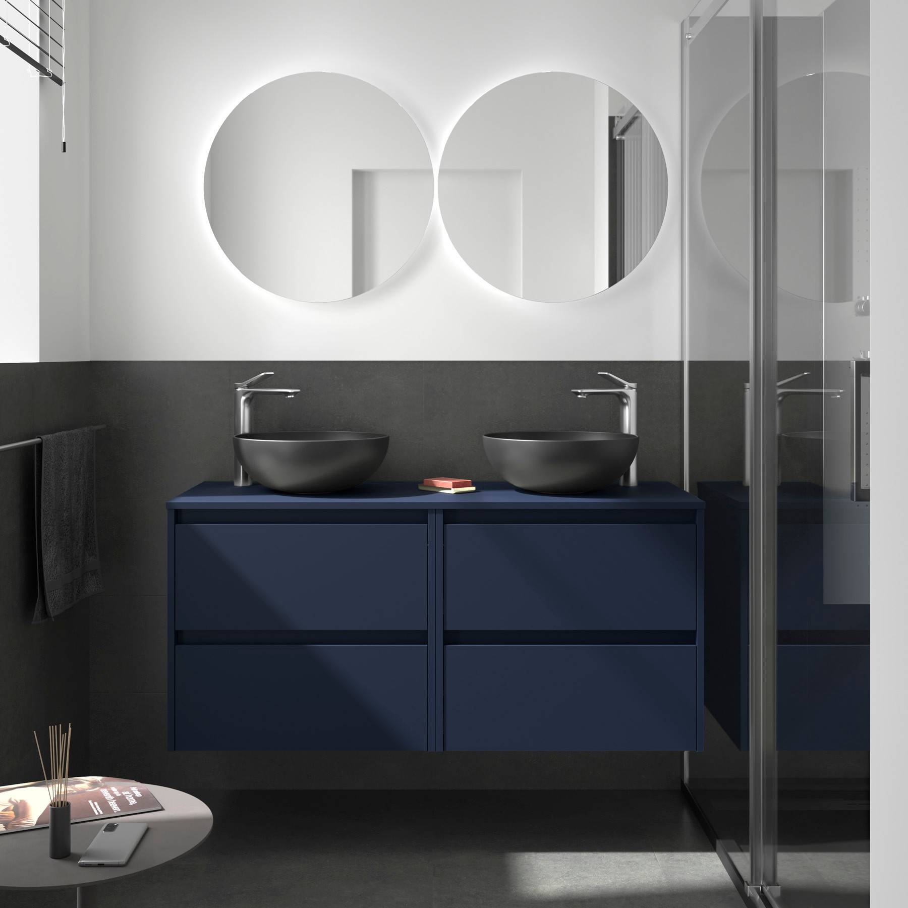 Zwei kreisrunde Spiegel hängen über einem Doppelwaschbecken mit blauen Schubladen in einem modernen Badezimmer mit Dusche in Glasausführung.