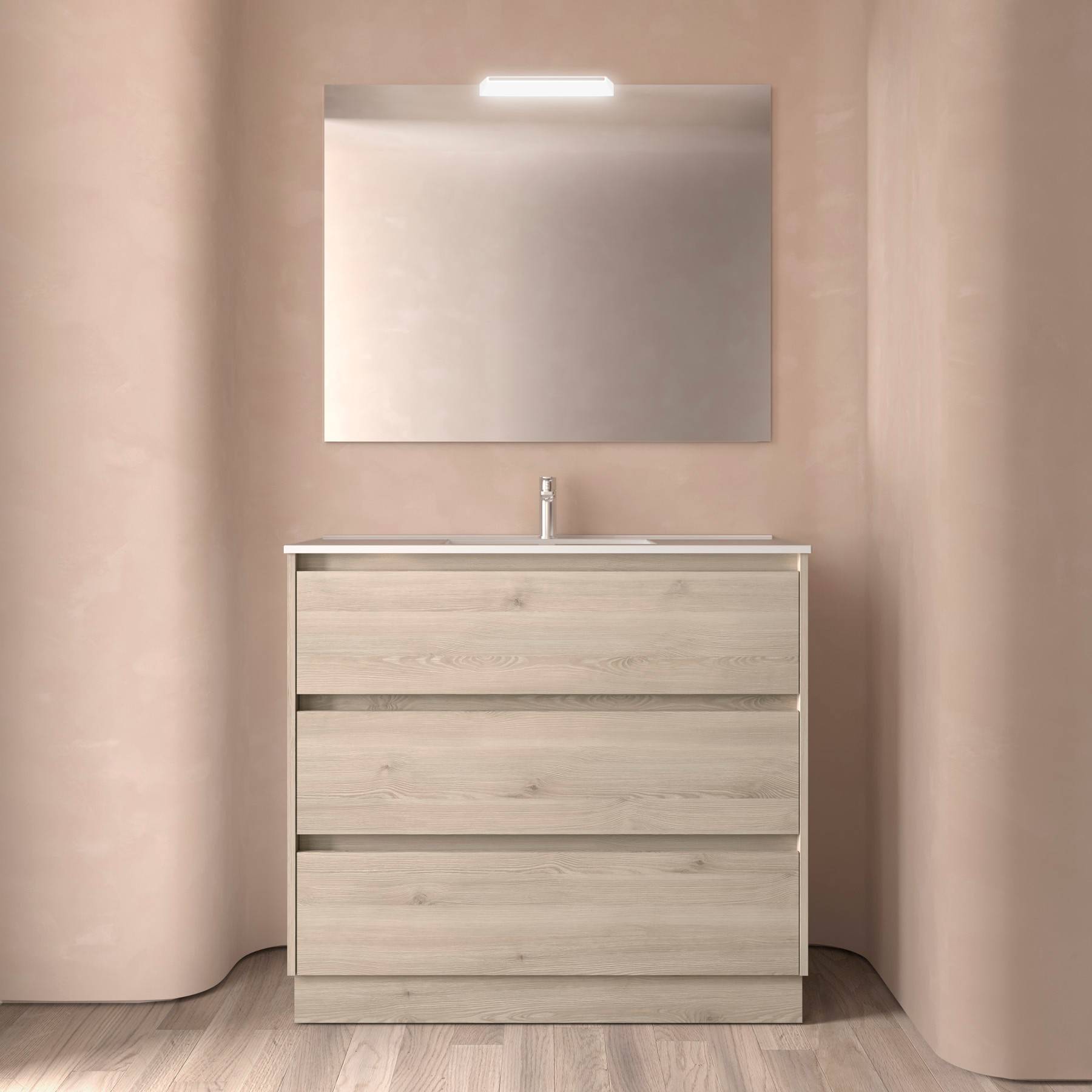 Eine minimalistische Badezimmereinrichtung zeigt einen hellen Holzwaschtisch mit drei Schubladen, einen rechteckigen Spiegel und Deckenbeleuchtung vor einer taupefarbenen Wand.