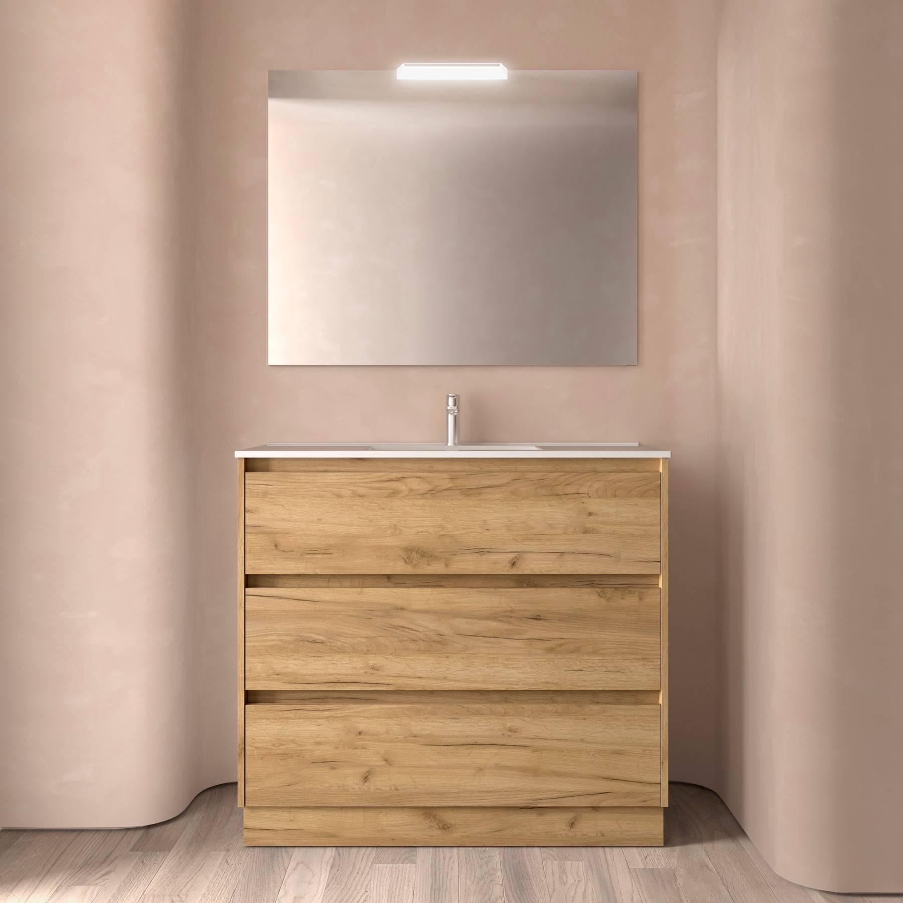 Eine moderne Badezimmereinrichtung besteht aus einem Waschtisch aus Holz mit drei Schubladen, einem schlichten rechteckigen Spiegel darüber und einer kleinen Deckenleuchte.