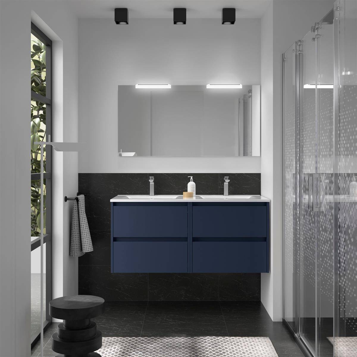 Modernes Badezimmer mit dunkelblauem Doppelwaschbecken, großem Spiegel, schwarzem Fliesenboden, Duschkabine und kleinem rundem Hocker neben einem Fenster.
