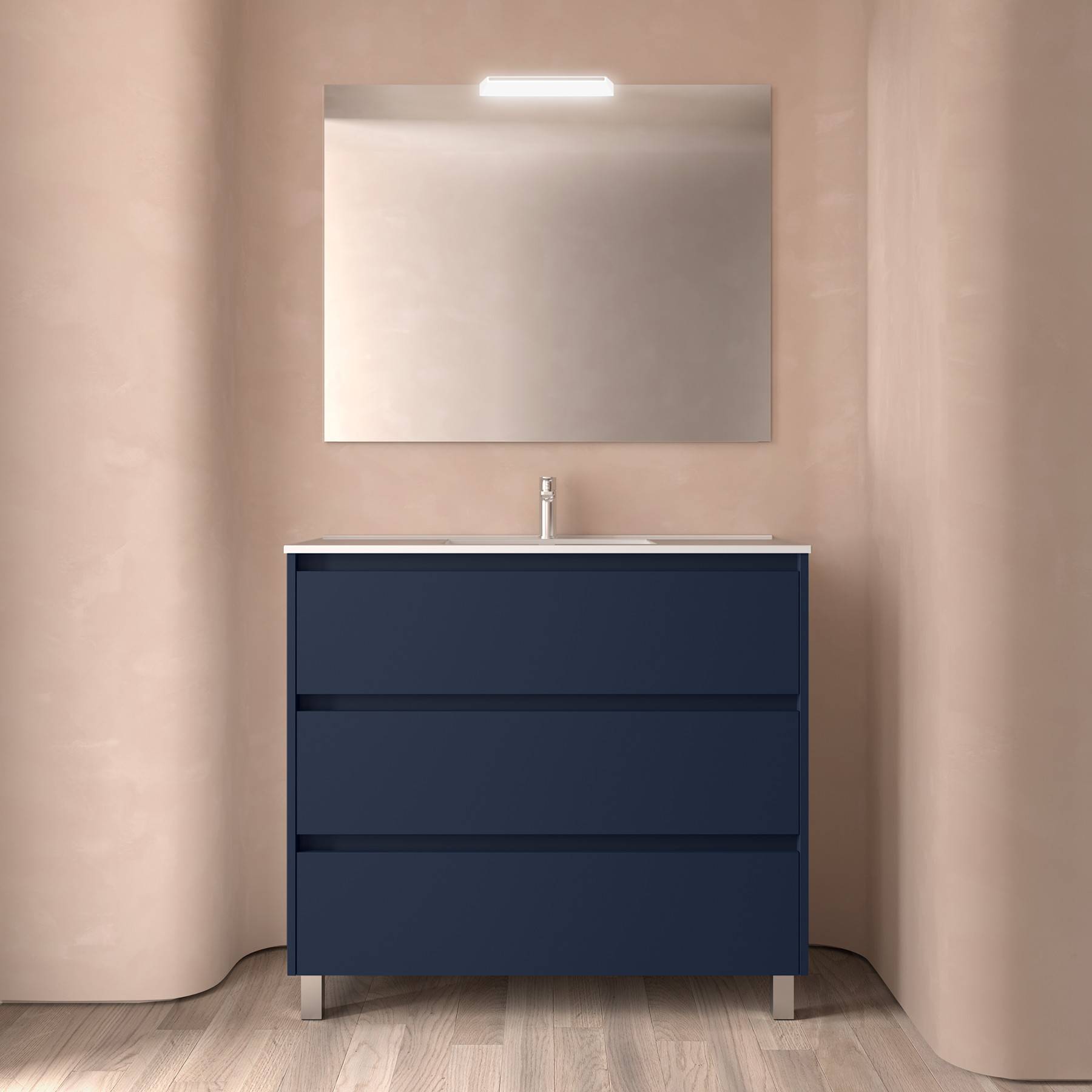 Marineblaue Badezimmerschrank mit drei Schubladen, einem Waschbecken und einem rechteckigen Spiegel darüber. Neutrale Wandfarbe und Holzfußboden.