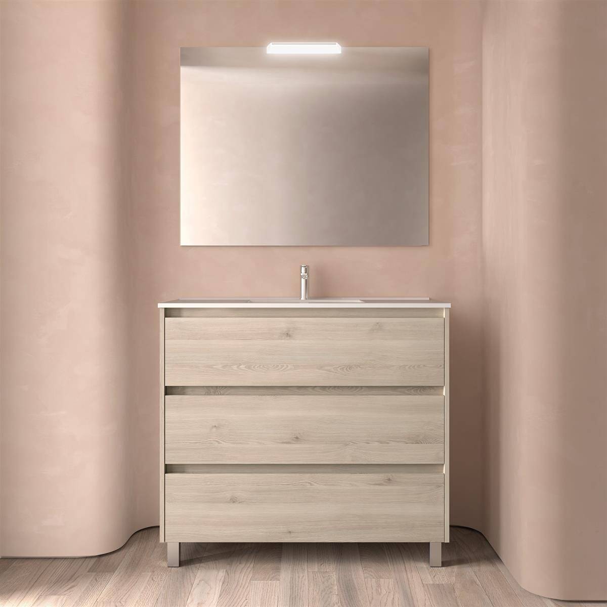 Modernes Badezimmer-Waschtisch mit hellholzfarbenen Schubladen, Waschbecken, Spiegel und einer beleuchteten Wandleuchte vor weich rosa geschwungenen Wänden.