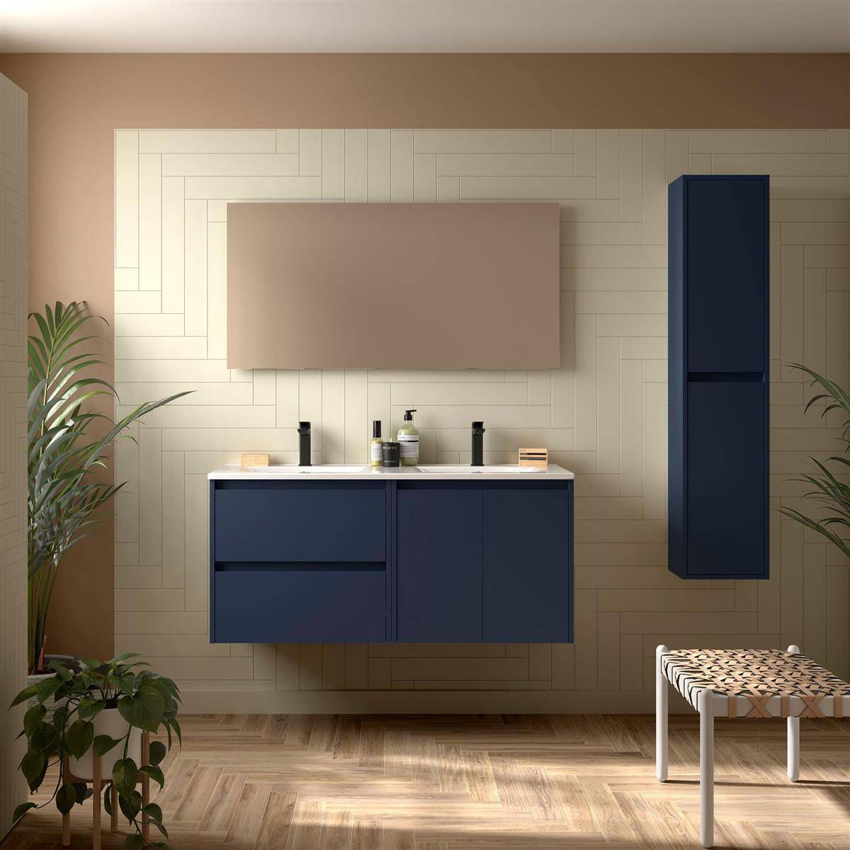Modernes Badezimmer mit marineblauer Waschtischanlage und Spiegelschrank an einer gemusterten beigefarbenen Wand, dazu ein hohes passendes Wandschrank und eine geflochtene Bank.
