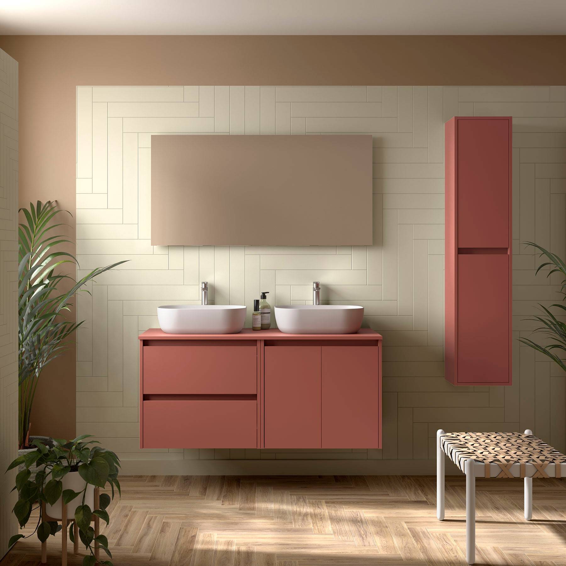 Ein modernes Badezimmer verfügt über eine beige Wand, zwei weiße Waschbecken auf einem rosa Waschtisch, einen passenden hohen Schrank, eine Bank und Topfpflanzen.