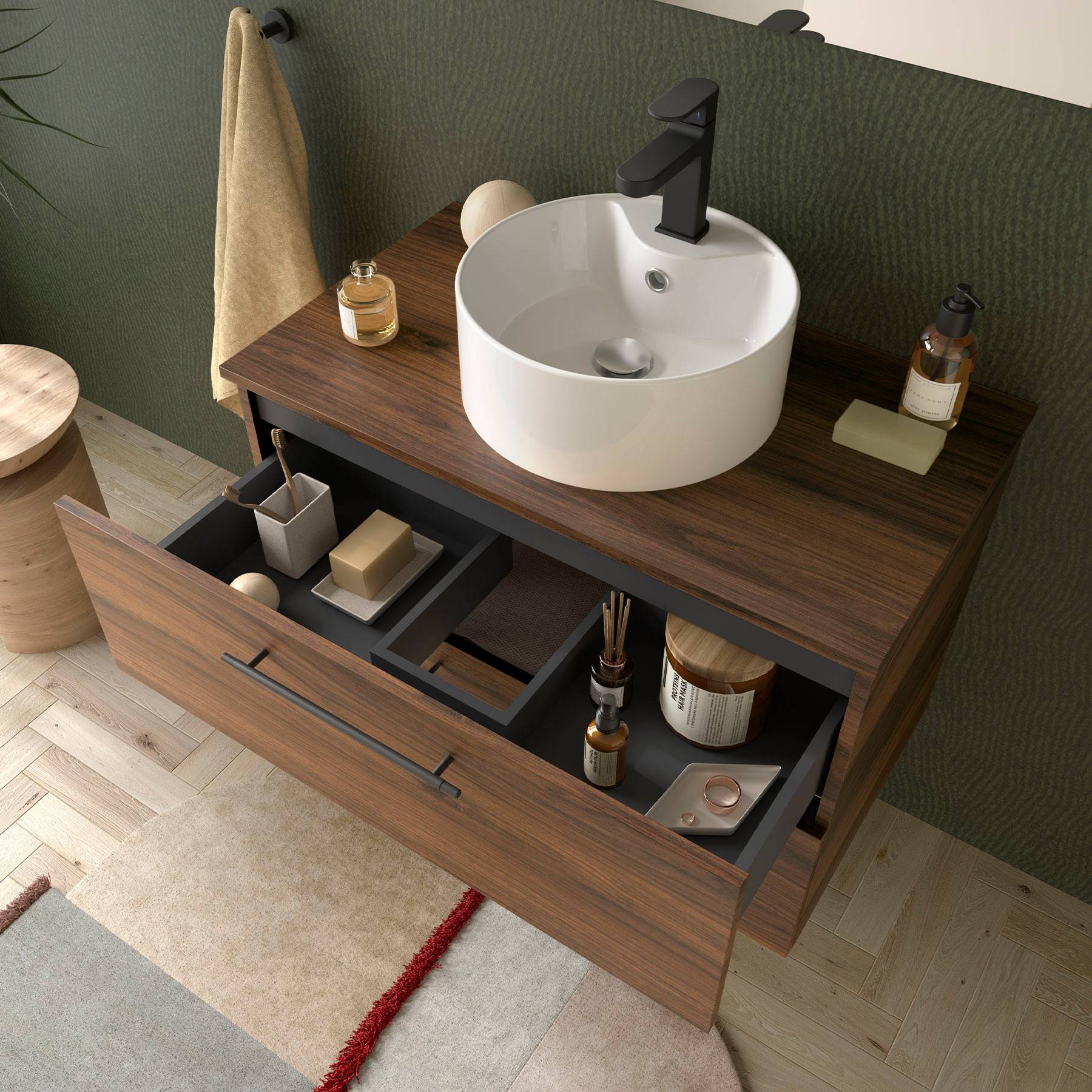 Moderner Badezimmerwaschtisch mit geöffneter Schublade, in der Toilettenartikel ordentlich organisiert sind; enthält ein rundes Waschbecken, schwarze Armatur, Seife und Handtuch.