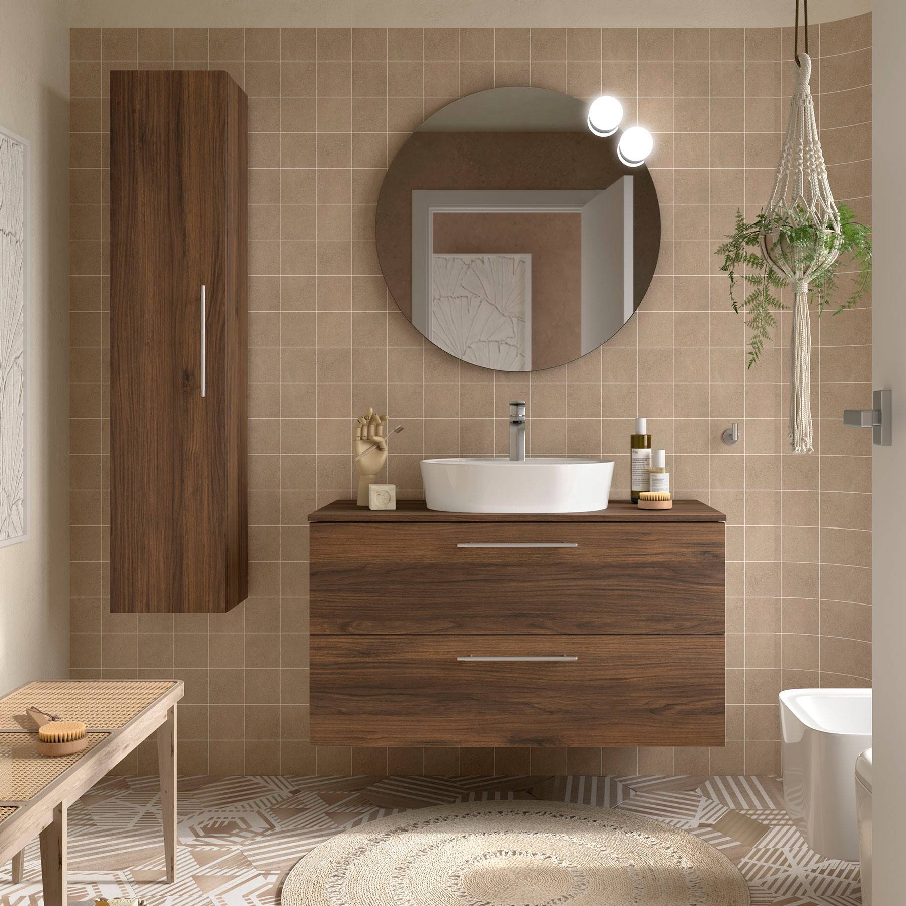 Modernes Badezimmer mit rundem Spiegel, Holzwaschtisch, weißem Waschbecken und hängender Pflanze. Beige Fliesen und ein gemusterter Boden verleihen Textur.