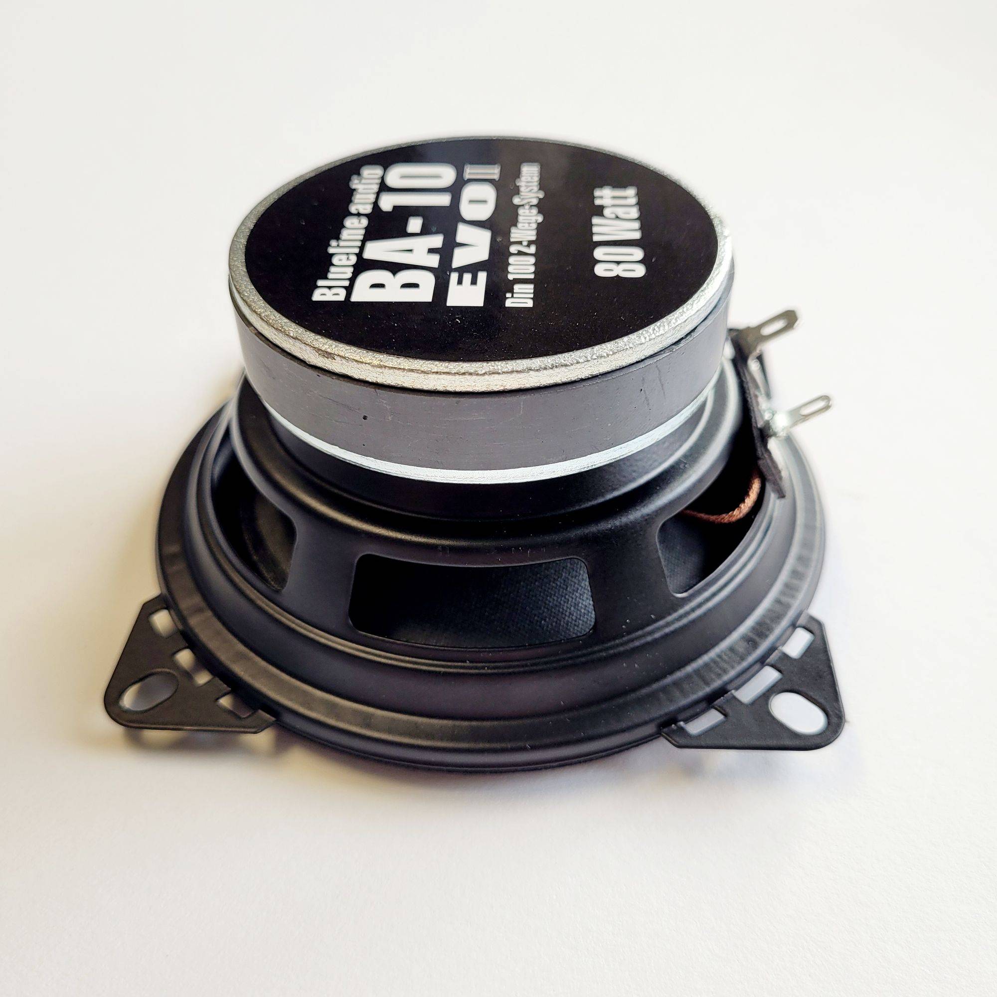 Ein runder schwarzer Lautsprecher mit metallischer Oberseite, beschriftet mit 