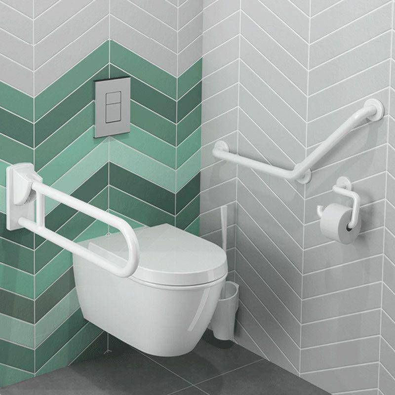 Zugängliches Toilettenklo mit weißen Haltegriffen und einem Spülknopf, das für Mobilitätsunterstützung konzipiert ist, mit grünen und grauen Chevron-gefliesten Wänden.