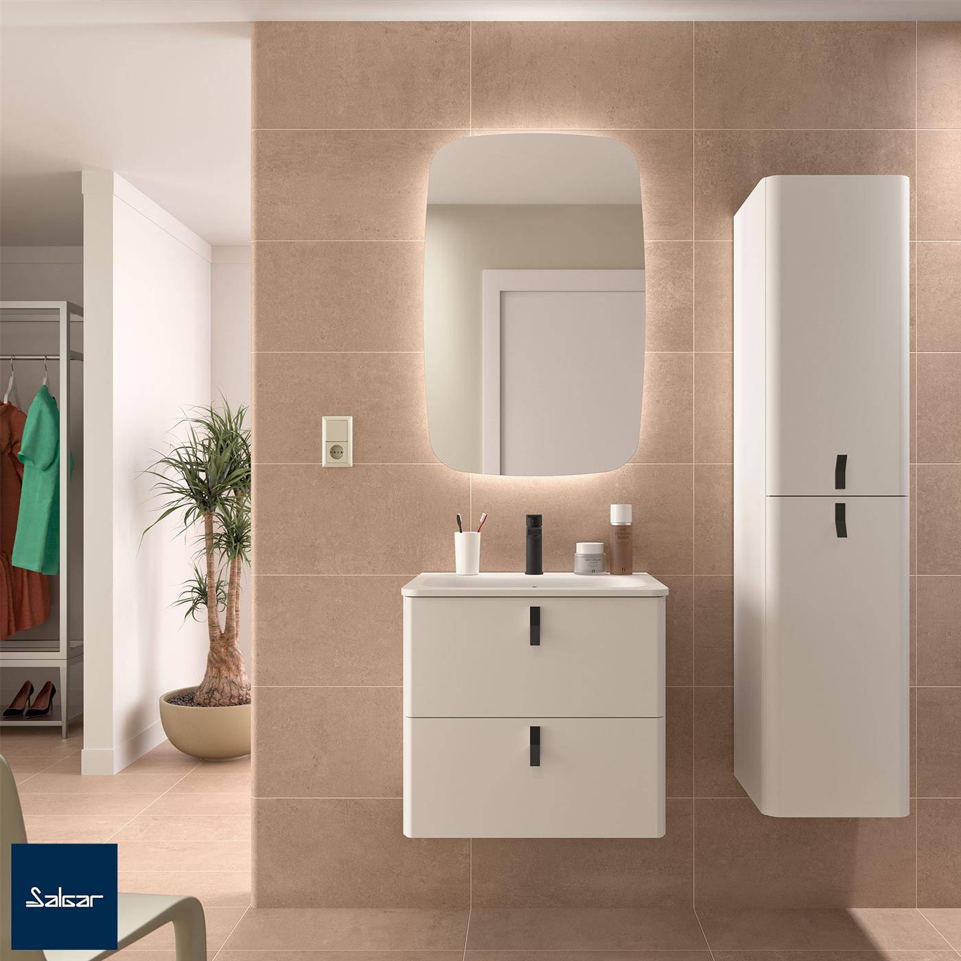 Modernes Badezimmer mit beigefarbener Fliesenwand, beleuchtetem Spiegel, wandmontiertem Waschtischschrank, hohhem Schrank und offenen Kleiderschrank mit sichtbarer Kleidung.