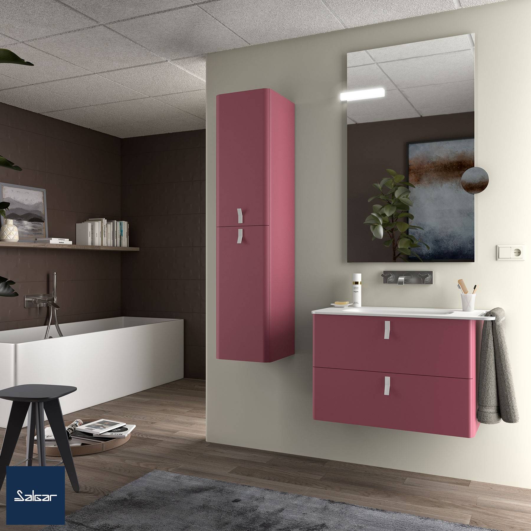 Ein modernes Badezimmer mit rosa Schränken, einem großen Spiegel und einem Handtuch an der Seite. Die Dekoration umfasst eine Pflanze und Bücher auf einem Regal.