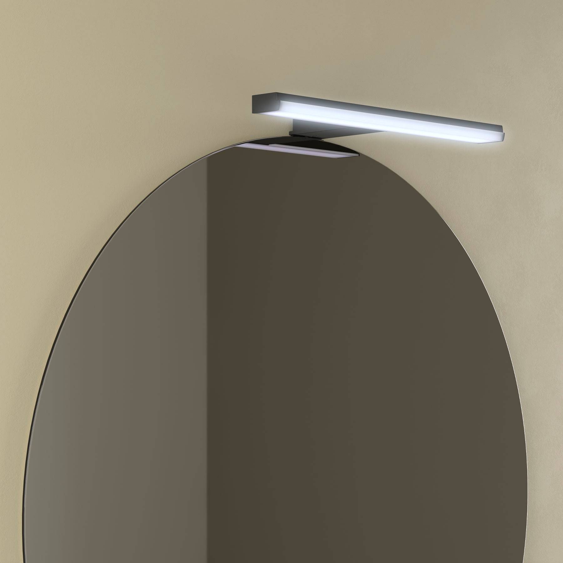 Ein ovaler Badezimmerspiegel, der an einer hellbeigen Wand montiert ist, mit einer rechteckigen LED-Leuchte darüber.