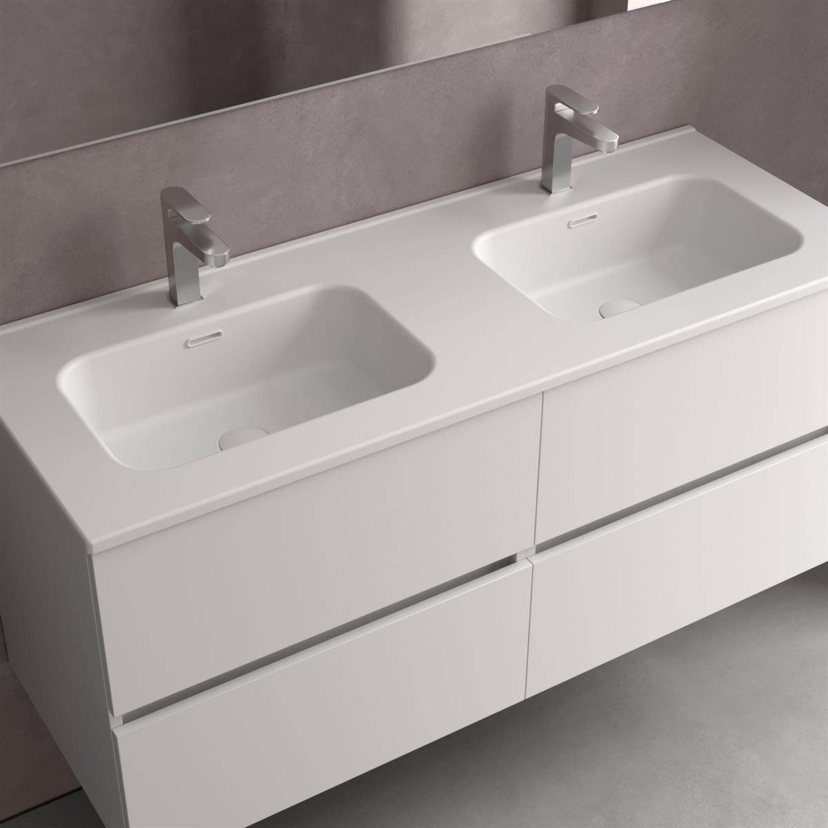 Moderne weiße Doppelwaschkommode mit zwei integrierten Waschbecken und Chromarmaturen vor einer grauen Wand.