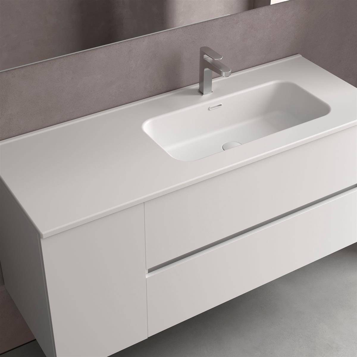 Weiße moderne Badezimmerkommode mit integriertem Waschbecken, einfach armatur und zwei Schubladen vor einer grauen Wand.