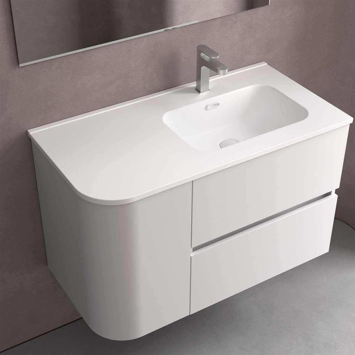 Modernes weißes Badezimmerwaschbecken mit integriertem Waschbecken, Chromarmatur, abgerundeter linker Seite und zwei Schubladen darunter.