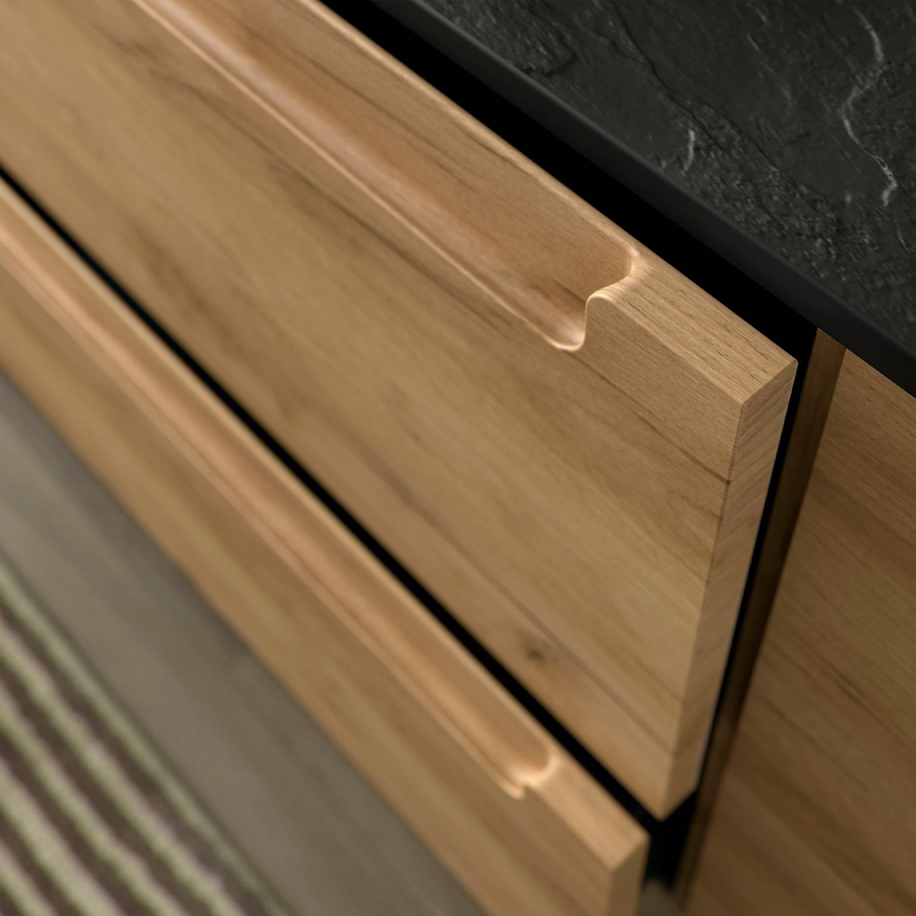 Holzkommode mit drei Schubladen, versehen mit geschnitzten Griffen, vor einem dunklen Arbeitsblatt und einem gestreiften Teppich.