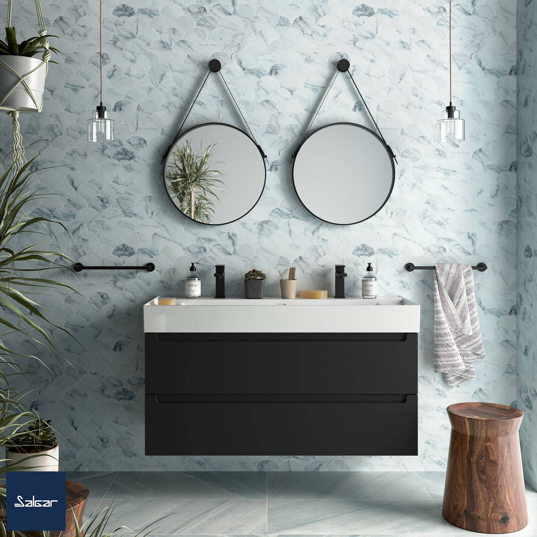 Ein modernes Badezimmer verfügt über eine Doppelwaschbecken-Waschtischplatte mit zwei runden Spiegeln, schwarzen Schubladen und dekorativen Pflanzen vor einer strukturierten Wand.