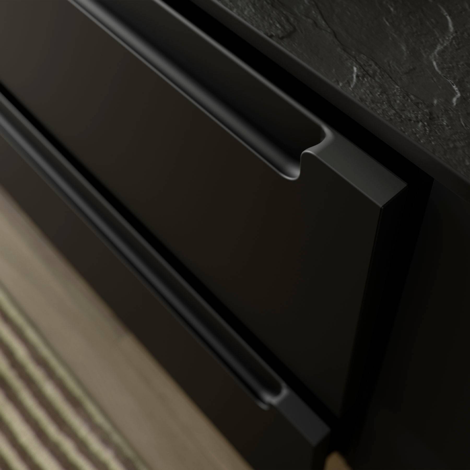 Nahaufnahme von eleganten, modernen schwarzen Schrankgriffen mit einer strukturierten Arbeitsplatte darüber, angrenzend an eine gestreifte Bodenmatte auf Holzfußboden.