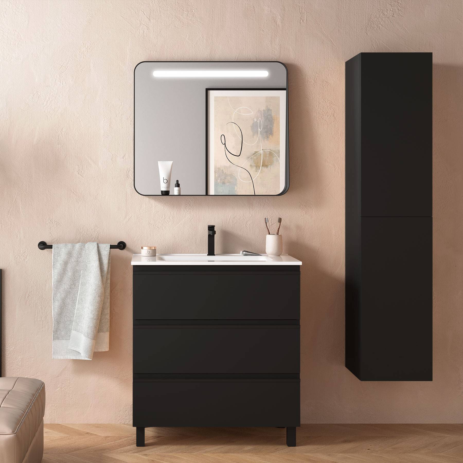 Modernes Badezimmer mit schwarzem Waschtisch, wandmontiertem Spiegel mit Beleuchtung und hohem Schrank. Neutrale Wände, Holzboden. Handtücher auf der Stange.