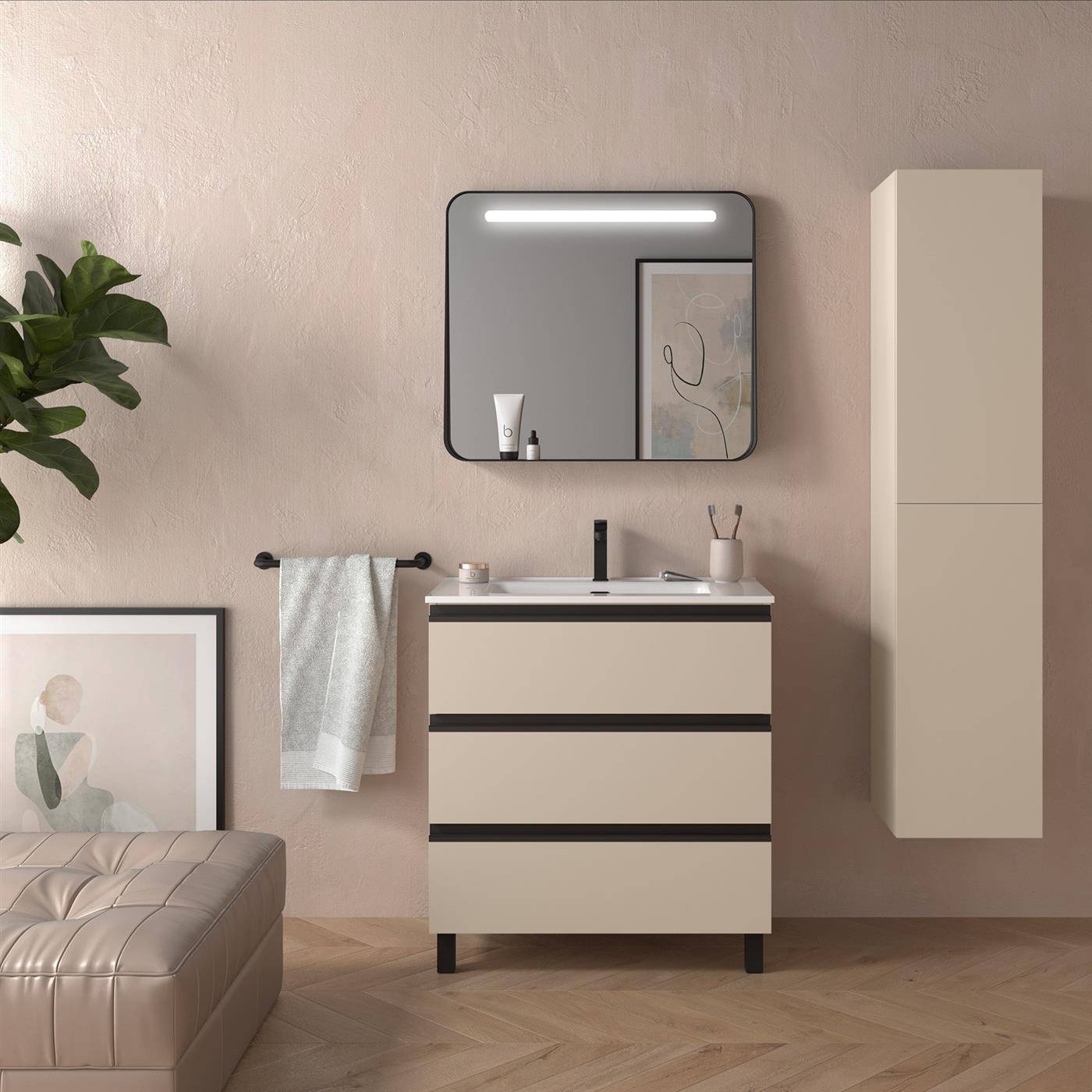 Modernes Badezimmer-Waschtisch mit Spiegel und Beleuchtung, beige Schrank und Wandaufbewahrung, Handtuchstange, Pflanze und gerahmte Kunst in einem weichen, neutralen Raum.