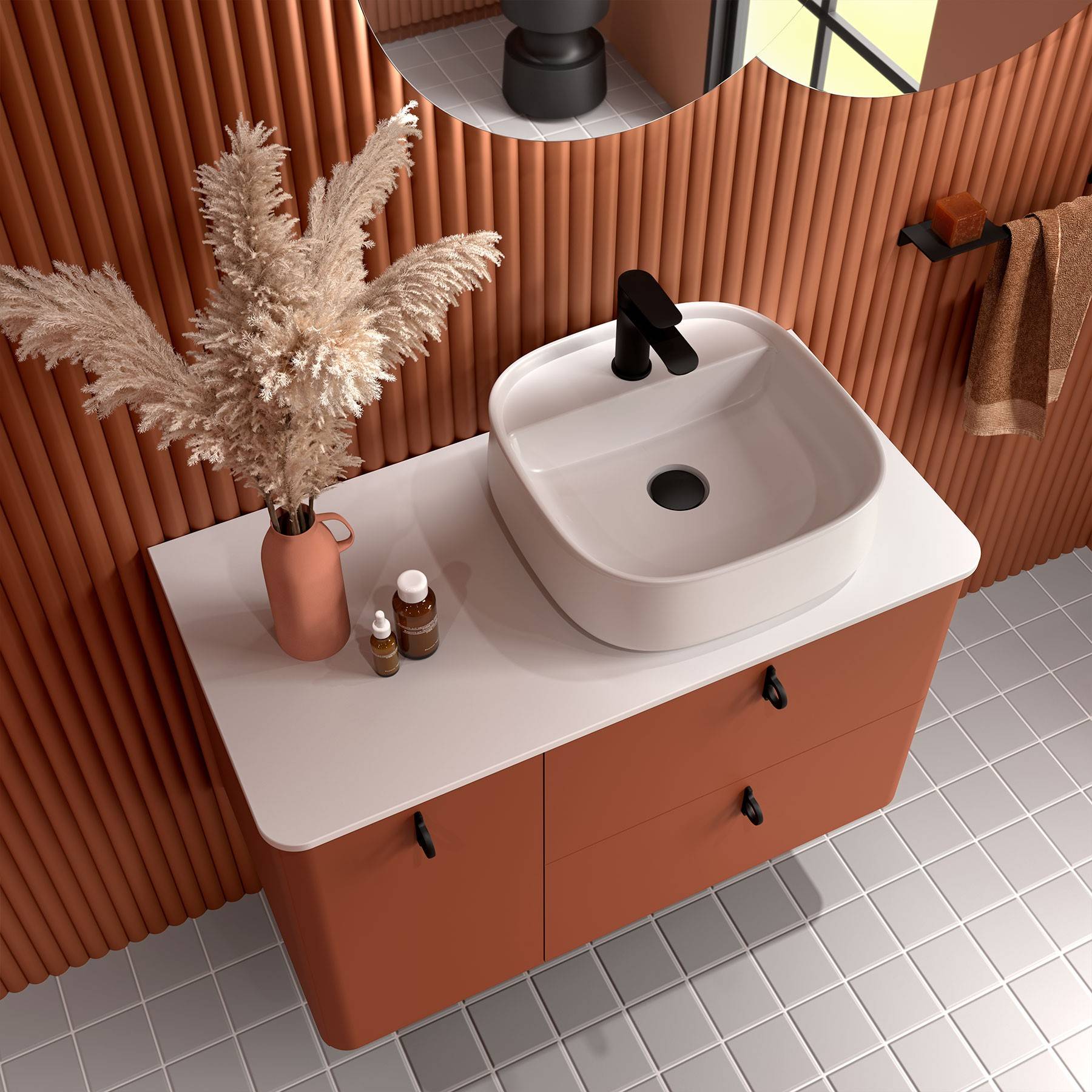 Modernes Badezimmer mit einem weißen quadratischen Waschbecken auf einem terrakottafarbenen Waschtisch, dekorativem Pampasgras in einer Vase, Messingarmatur und strukturierten Wänden.