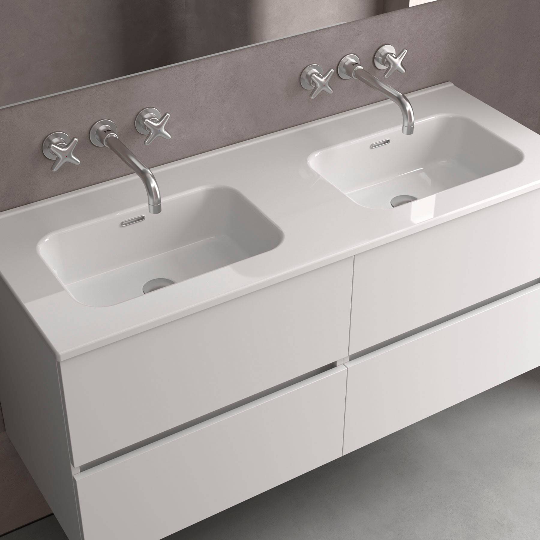 Ein modernes Badezimmer mit einem Waschtisch mit Doppelwaschbecken, Chrom-Armaturen und einem großen Spiegel vor einer neutral getönten Wand.