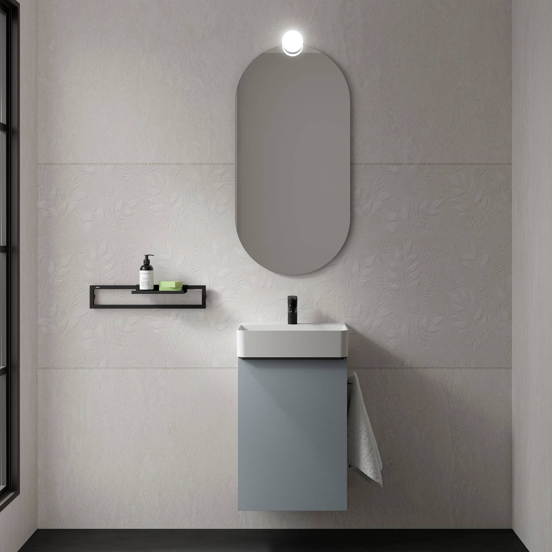 Ein modernes Badezimmer zeigt einen eleganten Waschbecken mit einem rechteckigen Spiegel und einem kleinen Regal, auf dem Seife und eine Pflanze stehen, vor einer strukturierten Wand.
