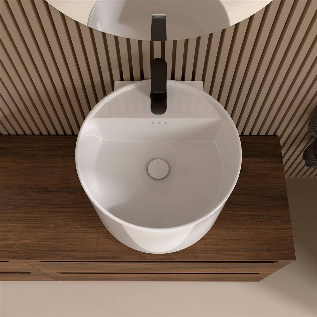 Modernes Badezimmerbecken mit einem schwarzen Armaturenset in einem weißen Aufsatzbecken auf einem Holzwaschtisch vor einer gestreiften Wand.