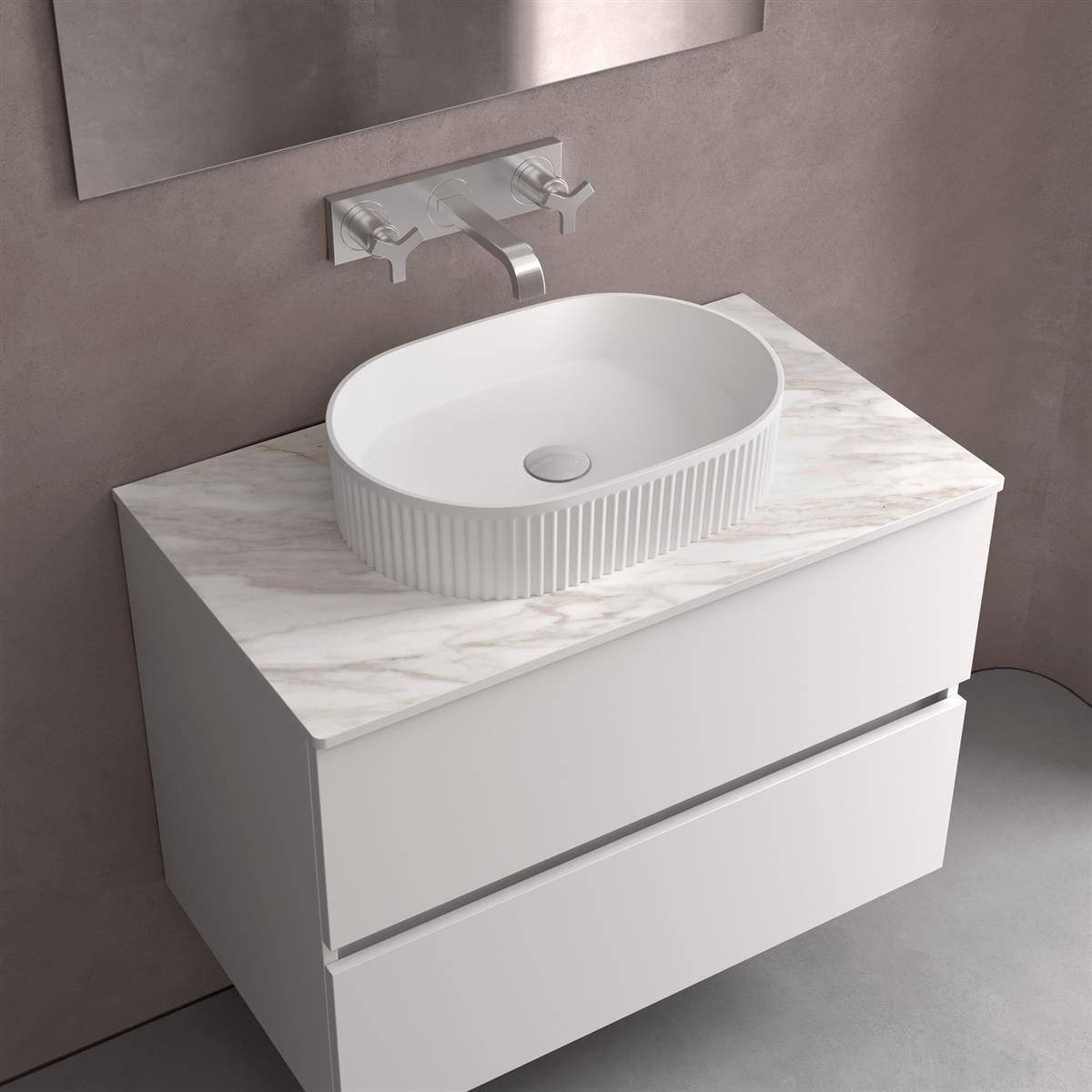 Modernes Badezimmer-Waschbecken mit einem weißen Aufsatzwaschbecken und einem an der Wand montierten Chromarmatur auf einer Marmor-Arbeitsplatte, vor einer grauen Wand dargestellt.