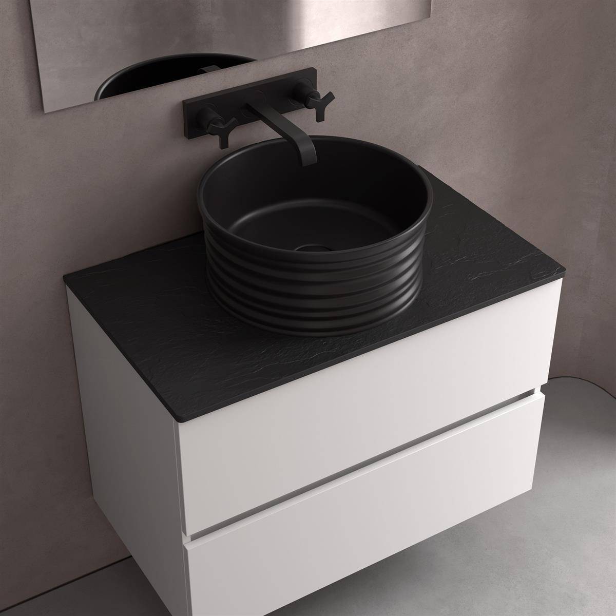 Modernes Badezimmerwaschtisch mit schwarzer Arbeitsplatte, rundem schwarzem Aufsatzwaschbecken, wandmontiertem Wasserhahn und zwei weißen Schubladen vor einer grauen Wand.