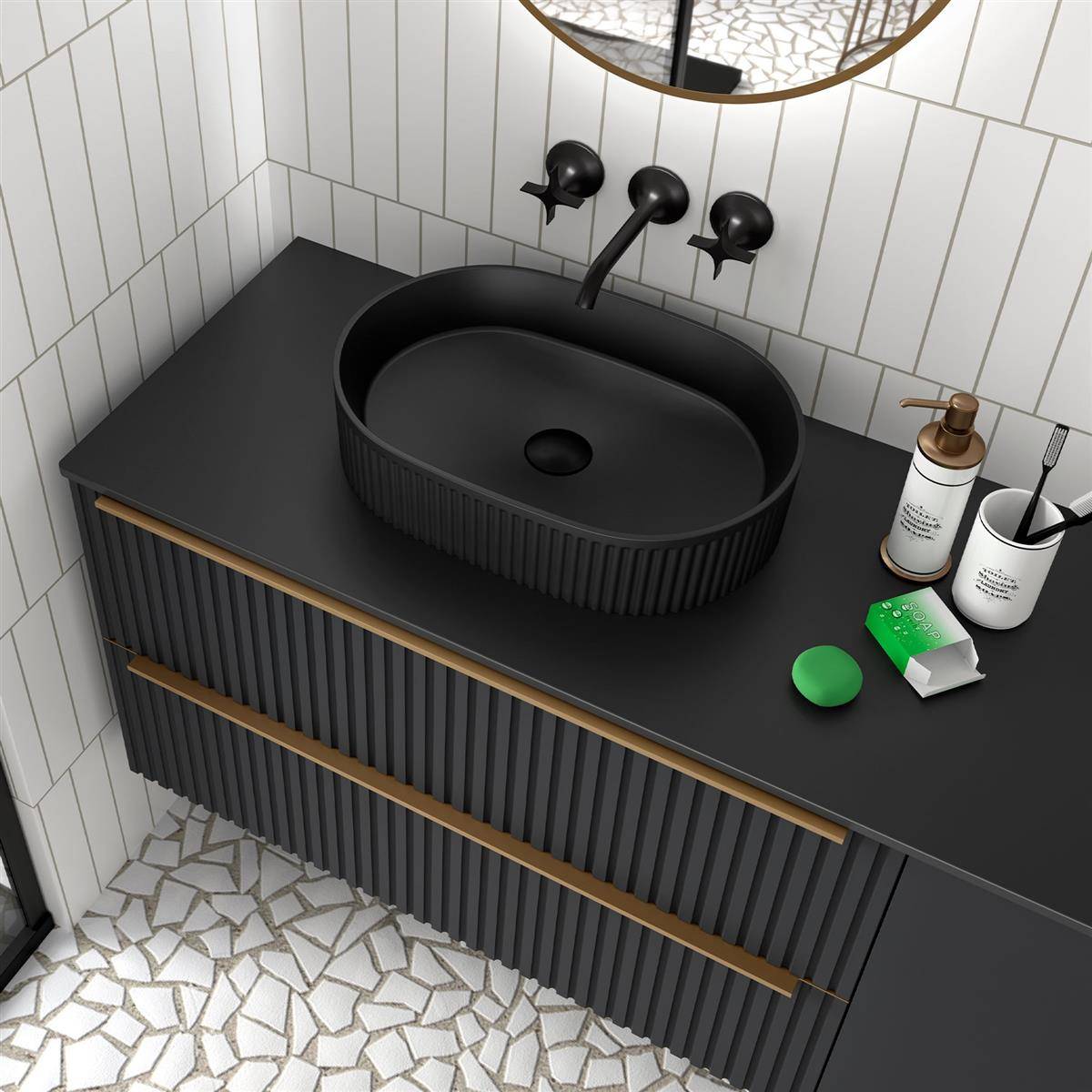 Modernes schwarzes Badezimmerwaschtisch mit ovalem Aufsatzwaschbecken, Wandarmatur, Seifenspendern und Toilettenartikeln auf schwarzer Arbeitsplatte über Mosaikfliesenboden.