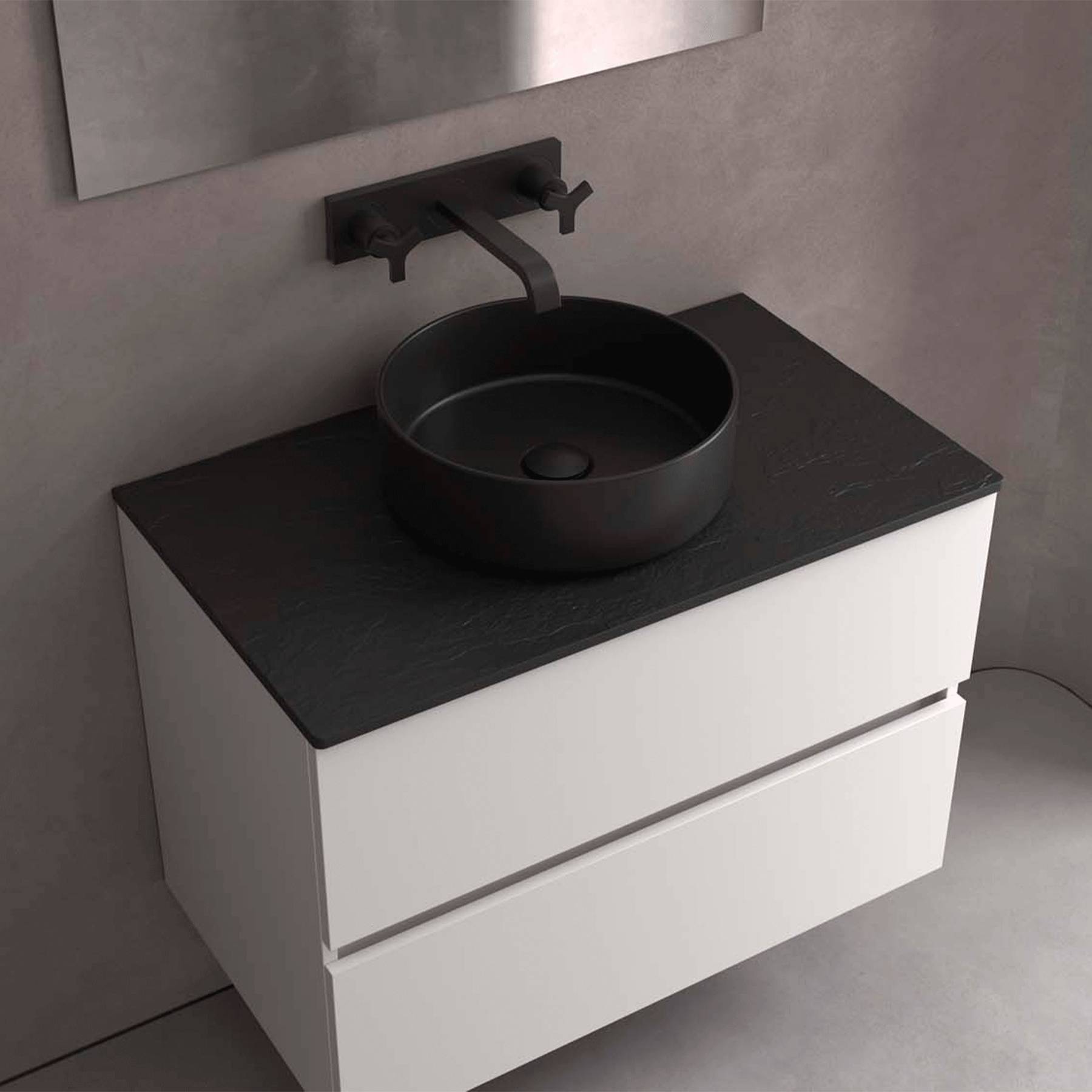 Ein modernes Badezimmer-Waschbecken präsentiert ein schwarzes rundes Aufsatzbecken mit einer wandmontierten Armatur über einem weißen Schrank mit zwei Schubladen.
