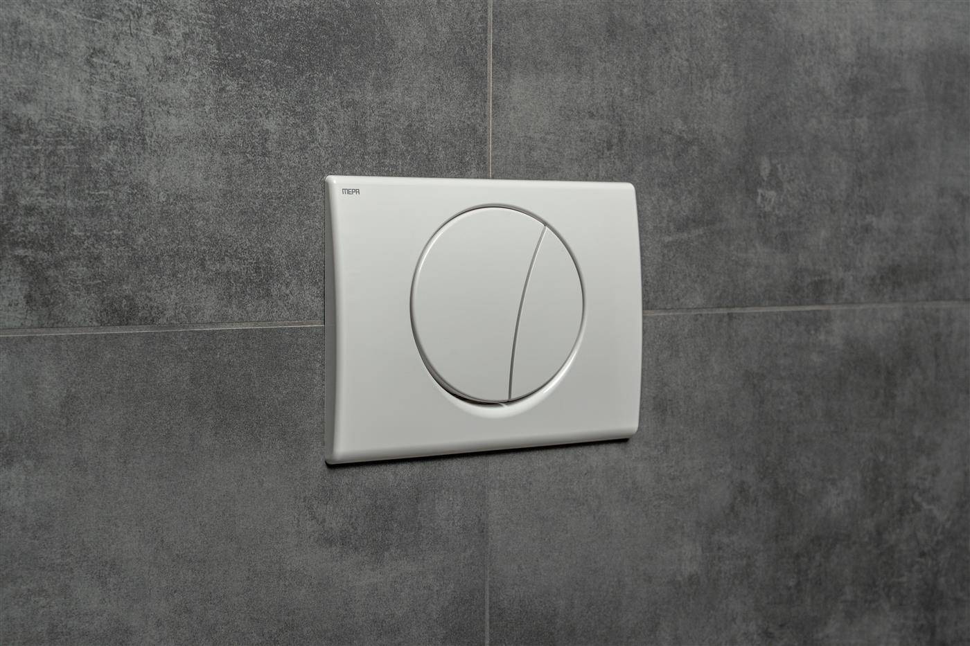 Weißes Dual-Flush-Toilettenknopffeld an einer grau gefliesten Wand montiert.