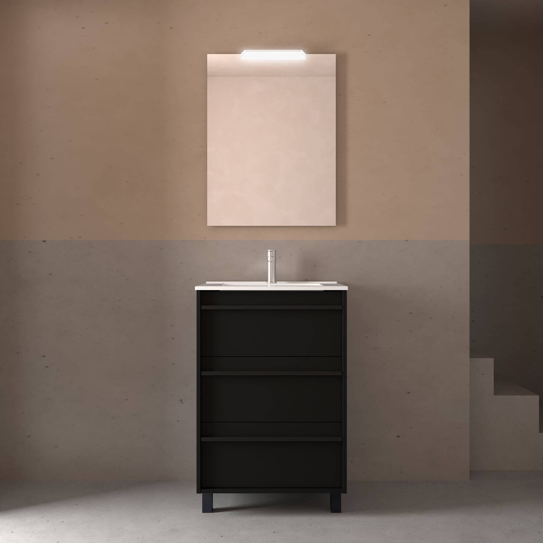 Ein minimalistisches Badezimmer zeigt einen schwarzen Waschtischunterschrank mit drei Schubladen unter einem rechteckigen Spiegel, der von einem Licht darüber beleuchtet wird.