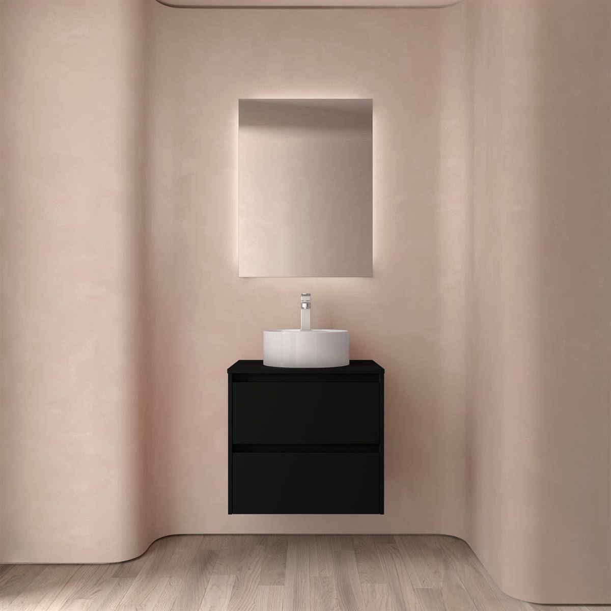 Minimalistischer Badezimmer-Waschtisch mit schwarzem Schrank, weißem Waschbecken und rechteckigem Spiegel vor weichen beigefarbenen gewölbten Wänden.