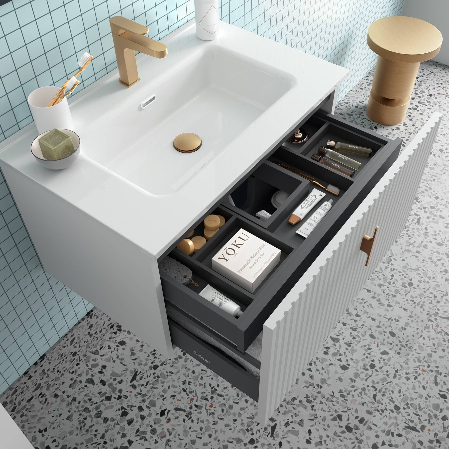 Ein Badezimmer-Waschtisch mit einer offenen Schublade, in der Toilettenartikel ordentlich sortiert sind, und ein Buch mit dem Titel „Yoku