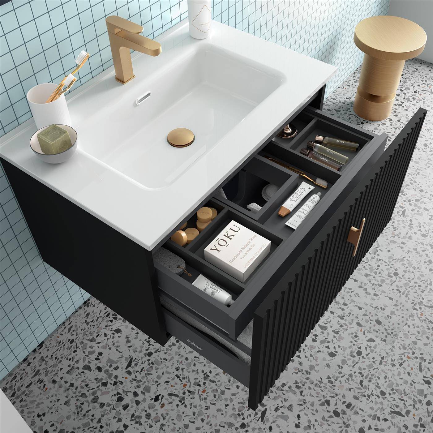 Modernes Badezimmerwaschtisch mit weißem Waschbecken und goldenem Wasserhahn, offene Schublade mit organisierten Toilettenartikeln und Pflegeprodukten.
