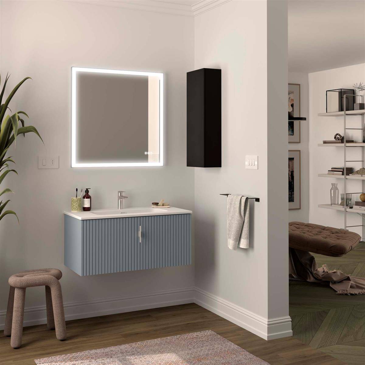 Modernes Badezimmer mit beleuchtetem Spiegel über einem blauen Waschtisch, Handtuchhalter, Hocker und offener Türöffnung zu einem Schlafzimmer oder Schrank.
