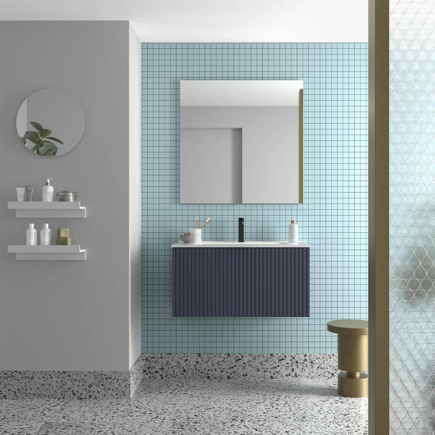 Modernes Badezimmer mit blauer Fliesenwand, schwebendem Waschtisch und Spiegel, Wandregalen, Terrazzoboden und einer teilweisen Glasschiebetür für die Dusche.