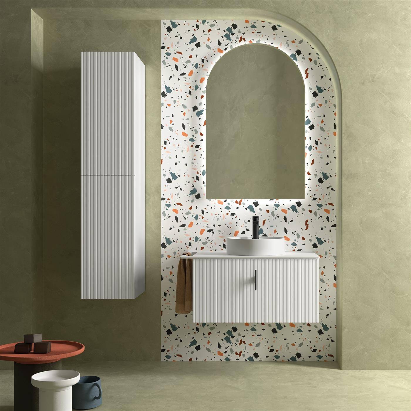 Modernes Badezimmer-Waschtisch mit terrazzogerahmtem Spiegelbogen, geripptem Schrank, Wandspeicher und kleinem Beistelltisch mit Schüssel und Krug.