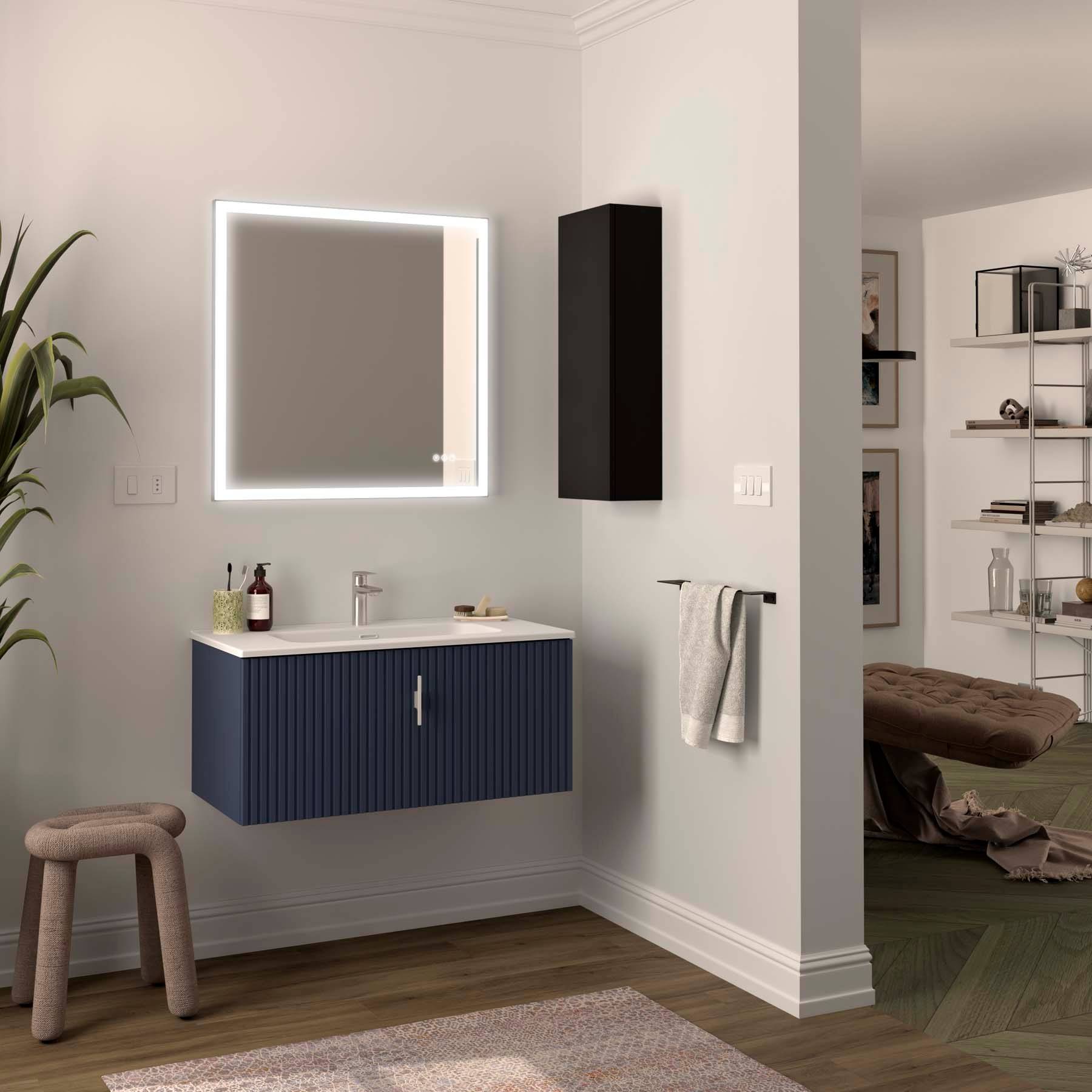 Ein modernes Badezimmer mit einem blauen Waschtisch, beleuchtetem Spiegel und einem Handtuch an der Stange. Daneben befindet sich ein Wohnzimmer mit Bücherregalen und Dekoration.